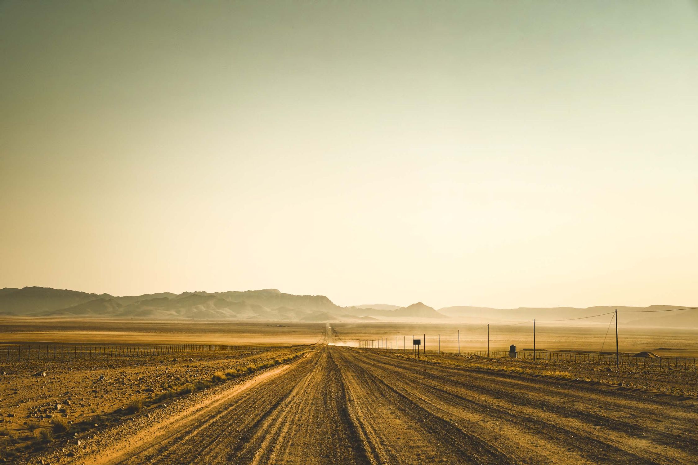 A 4x4 driving a gravel road through open Namibian country
