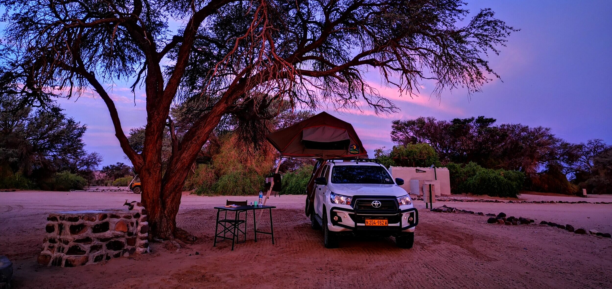 A clear view of a modern 4x4 campsite at dusk in Namibia