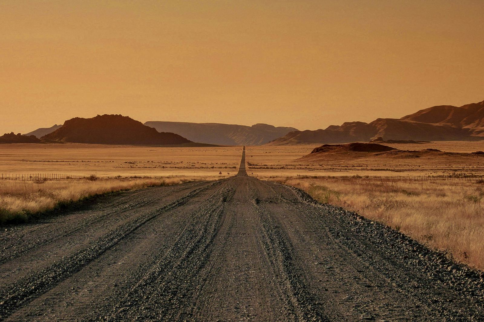 A gravel road crossing open Namibian country